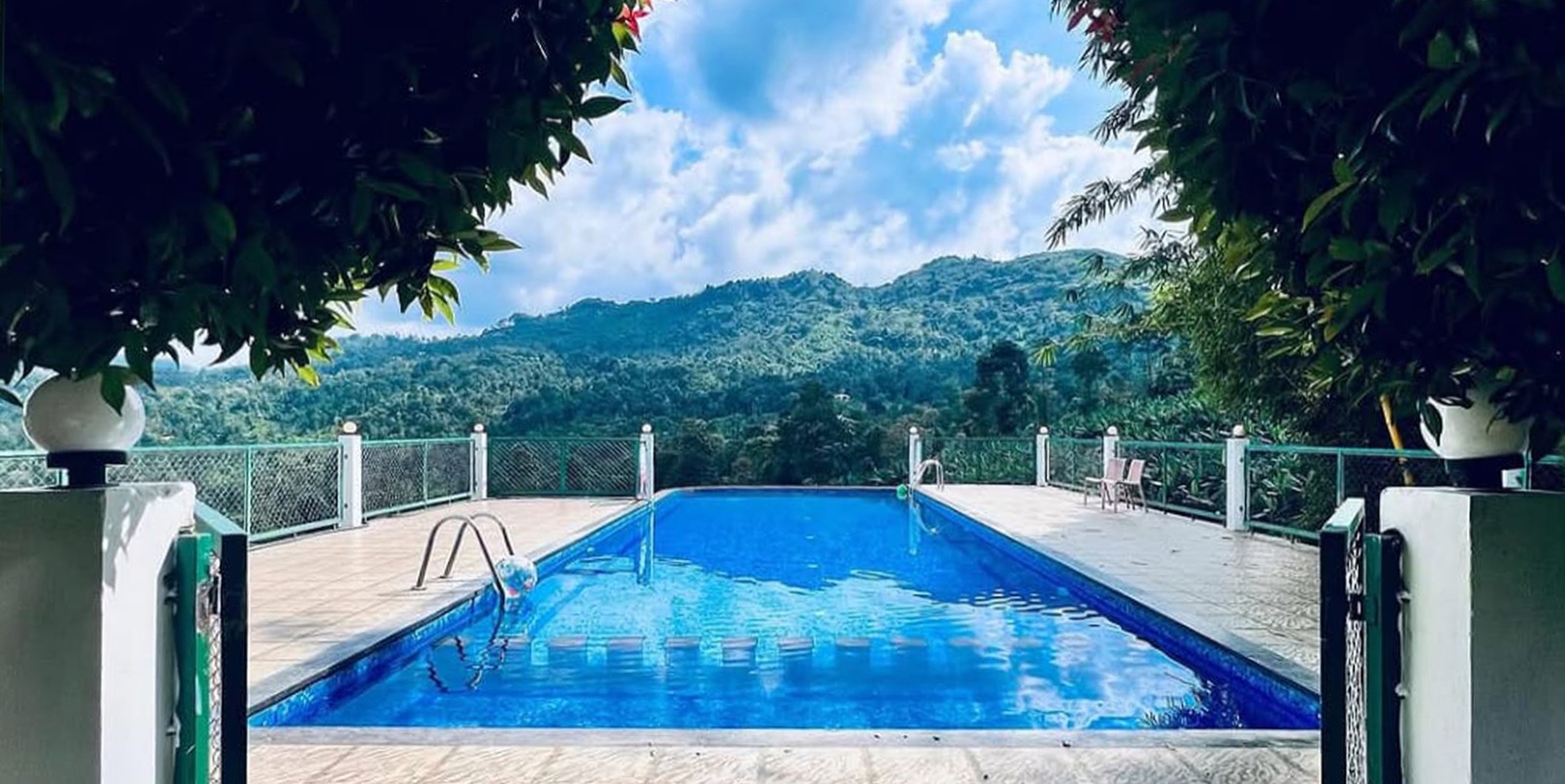 Actual swimming pool at Sylvan Hills with Kakkadampoyil hills behind it